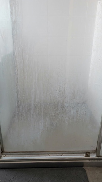 Shower screen before a detailed bathroom clean